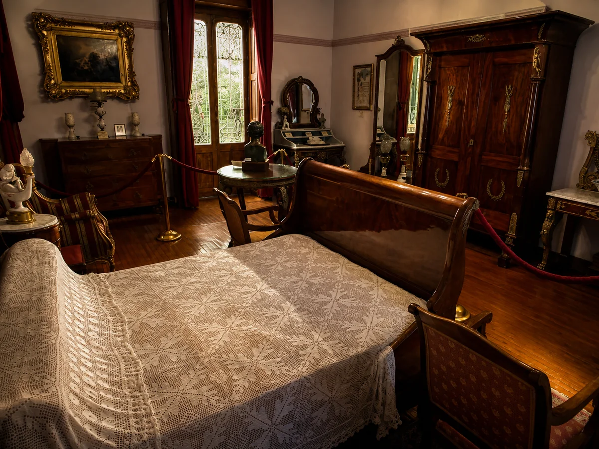 La recámara, con su cama de dosel rojo y sus bustos de bronce